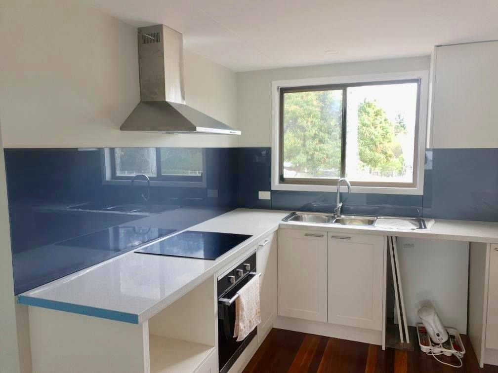 A Kitchen With White Cabinets , A Stove Top Oven , A Sink And A Window — Ace Glass & Aluminium In Grafton, NSW