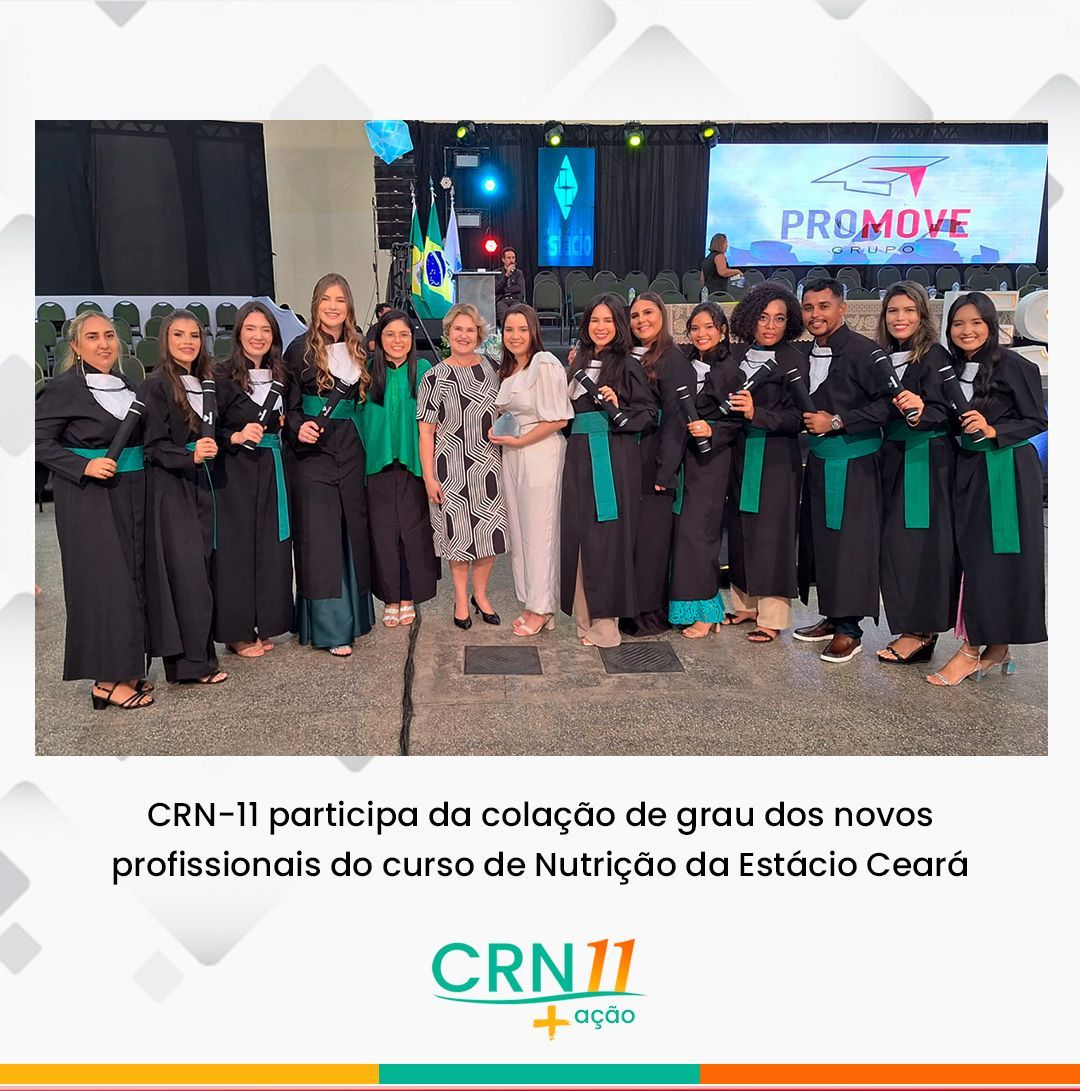 Grupo de formandos posa em cerimônia de colação da Nutrição da Estácio Ceará, com palco e tela ao fundo
