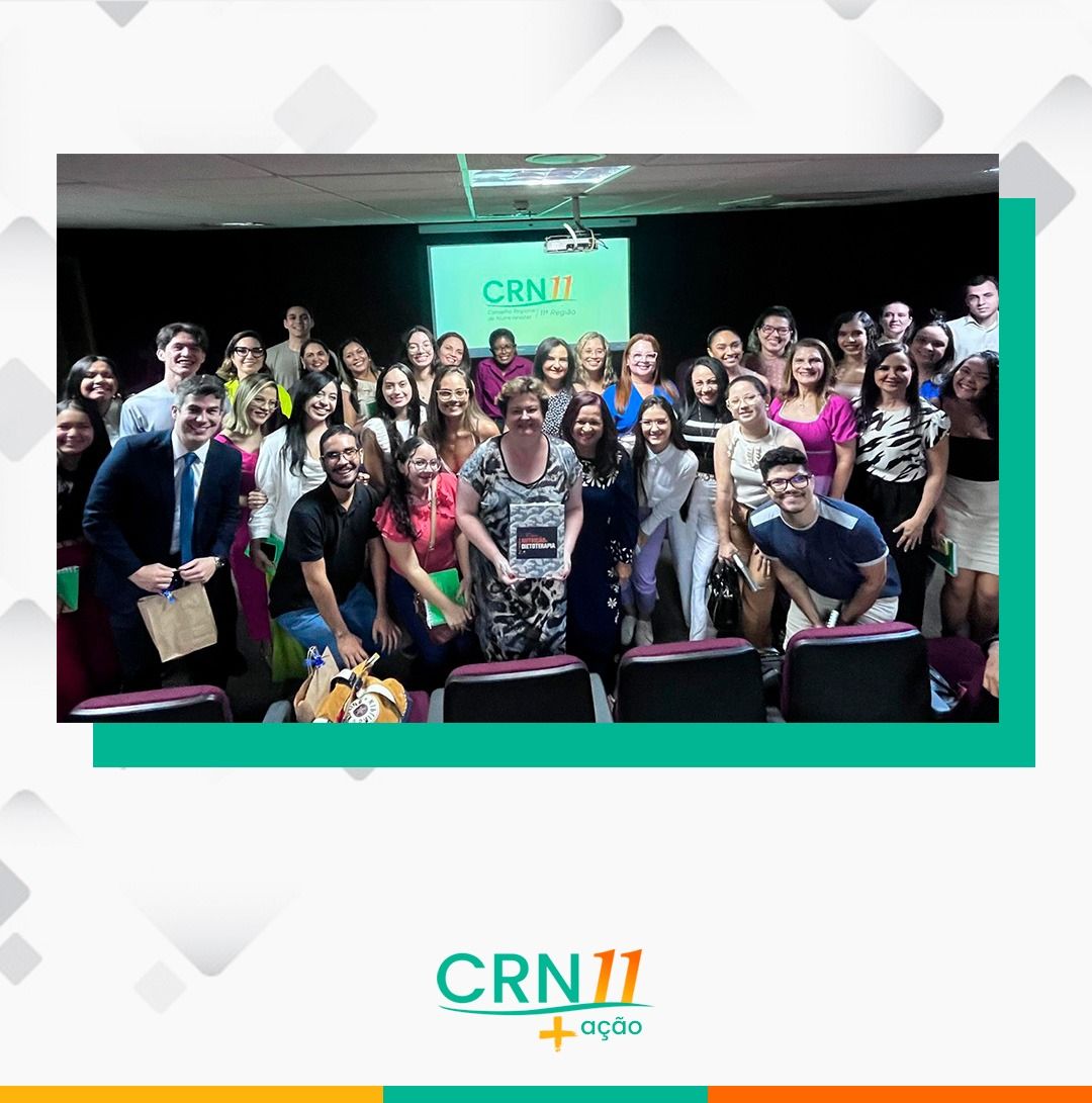 Grande grupo posando para uma foto de evento da CRNI em frente a um fundo verde.