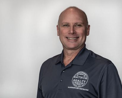 A man in a blue shirt is smiling for the camera.