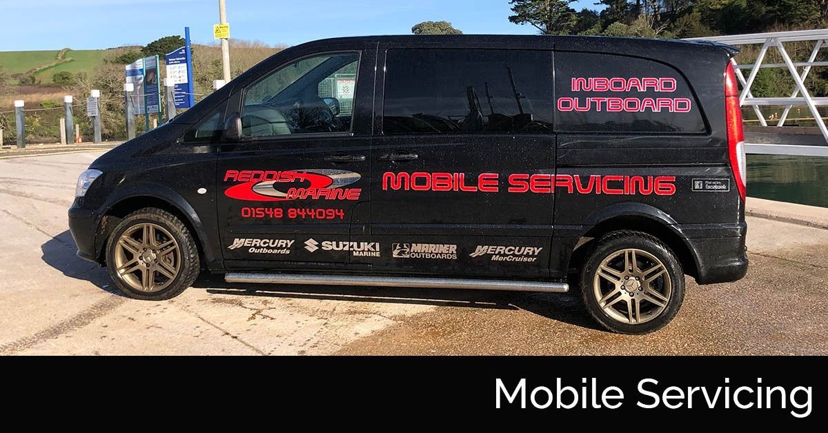 Black mobile service van with red logos parked outdoors in bright sunlight