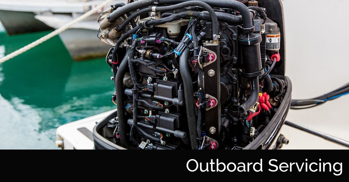 Close-up of a boat outboard motor being serviced, with black hoses and engine parts
