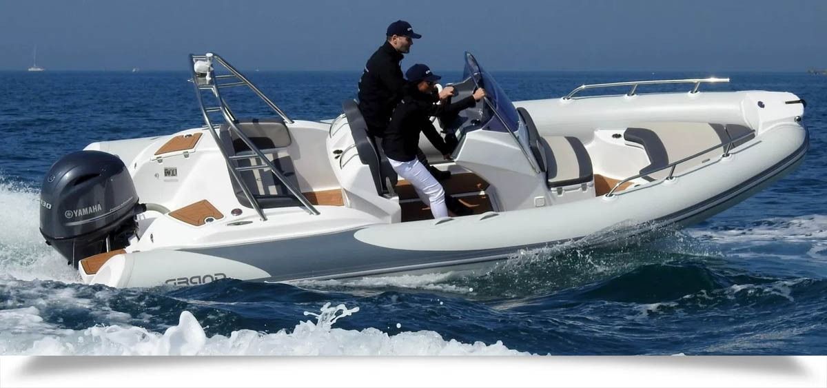 White inflatable speedboat racing across the ocean with two people aboard
