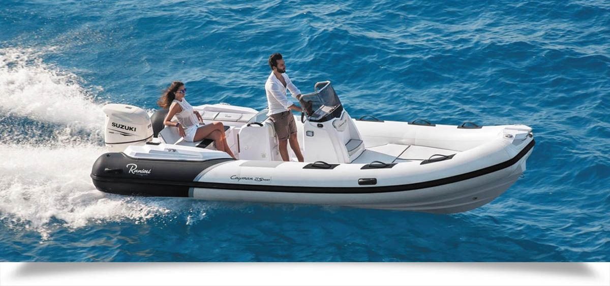 Three people riding a white inflatable grand silver line 370 speedboat across bright blue water