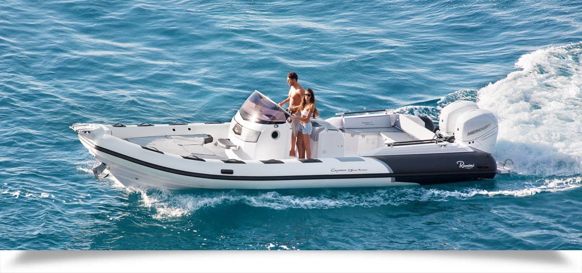 Small white motorboat with two people speeding across blue water, leaving a foamy wake