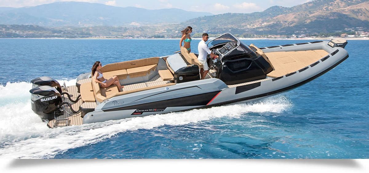 Speedboat cruising on blue water with two passengers, mountains in the background