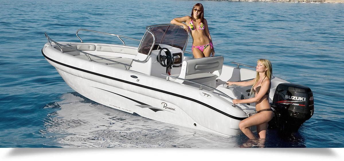 Two women on a small white motorboat speeding across blue water