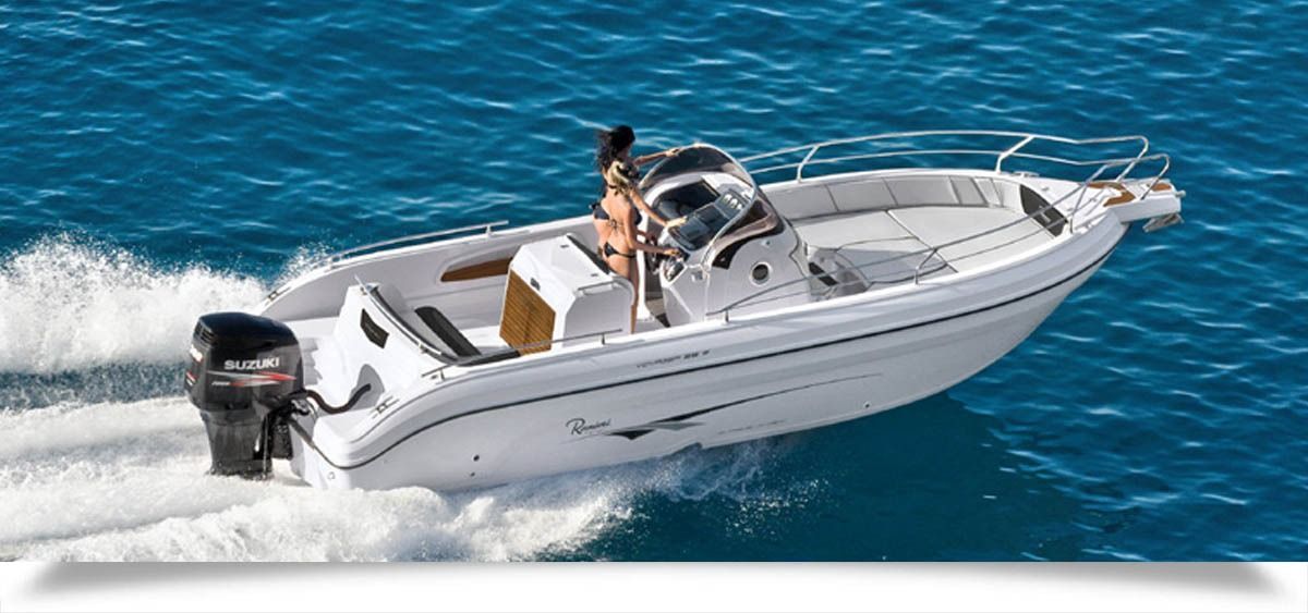 White speedboat cruising on blue water, leaving a foamy wake
