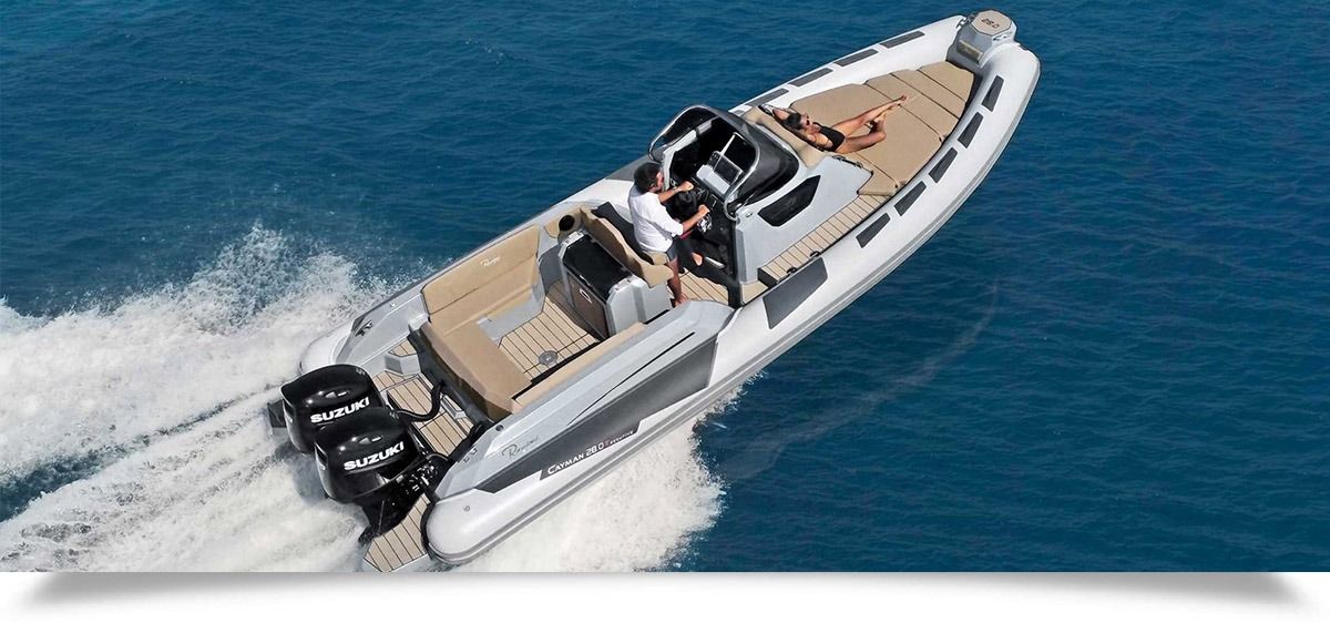 Motorboat speeding over blue water, leaving a white wake, with two people aboard
