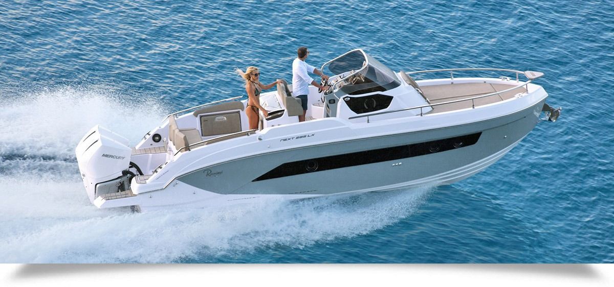 Luxury white motor yacht speeding across blue water with people on deck