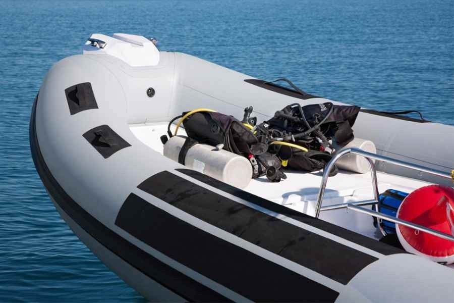 Inflatable ranieri cayman 23 sport diving rib boat with a visible engine, floating on calm blue water