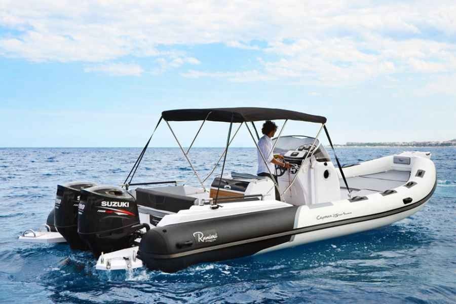 White motorboat on blue water with a person at the helm and a black outboard motor