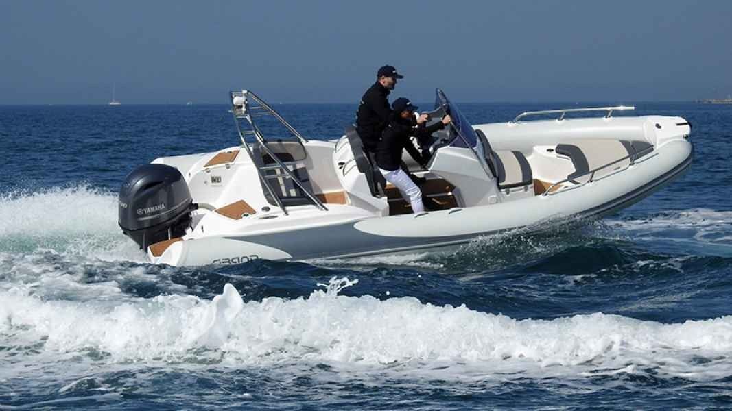 Person steering a white inflatable speedboat, skimming across choppy blue water with spray around it