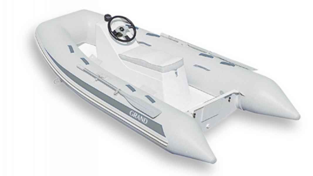 White inflatable grand silver line 300 dinghy with steering wheel and seats on a plain white background