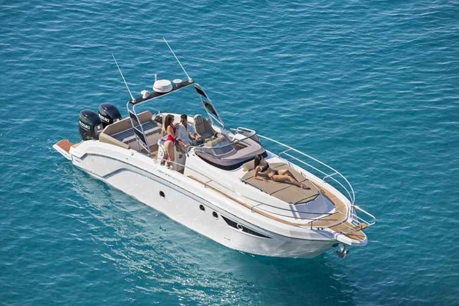 White motor boat cruising on blue water with several people aboard