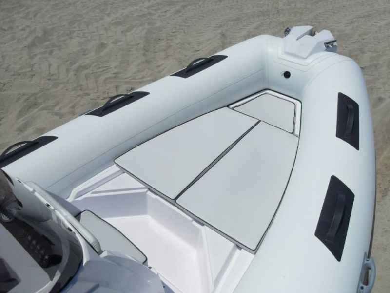 White inflatable boat viewed from above on sandy shore