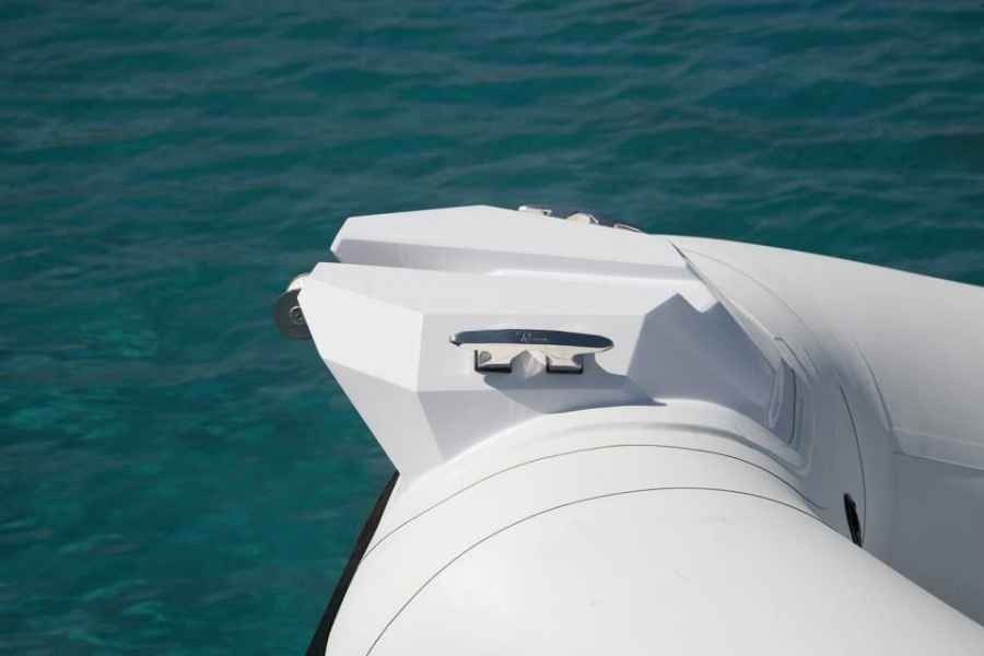 White boat bow on turquoise water, with a small mounted device near the front