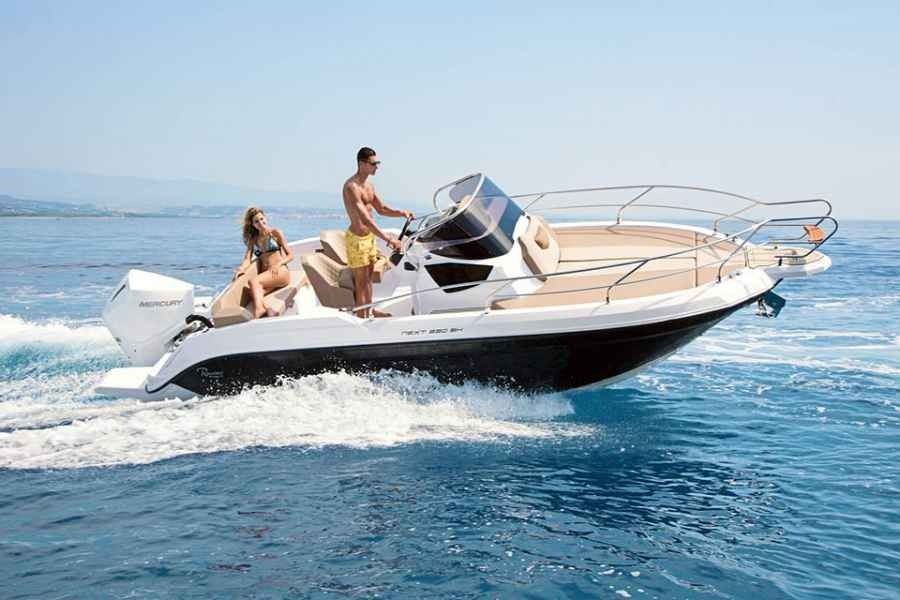 Two people on a white speedboat cutting across blue water on a sunny day