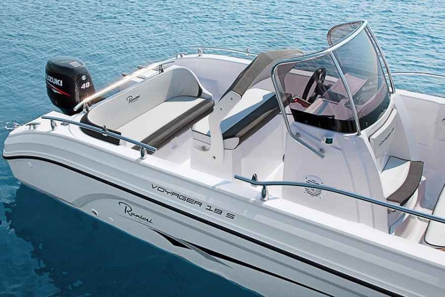 White speedboat on blue water with windshield and black outboard motor