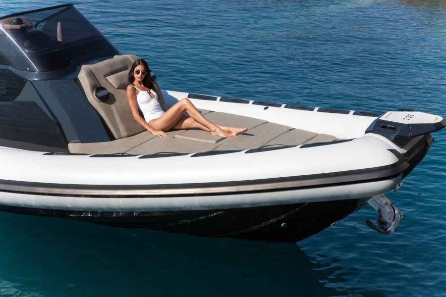 Woman relaxing on a white boat cruising over blue water