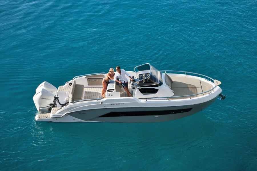 White motorboat cruising on turquoise water with two people on board