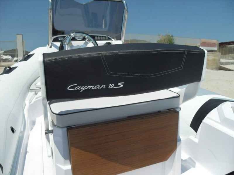 Cockpit of a white Chaparral 18 S boat with black seating and wood trim in bright sunlight