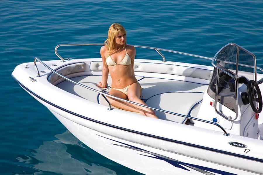 Woman in a white bikini on a small white ranieri voyager 17  boat in calm blue water