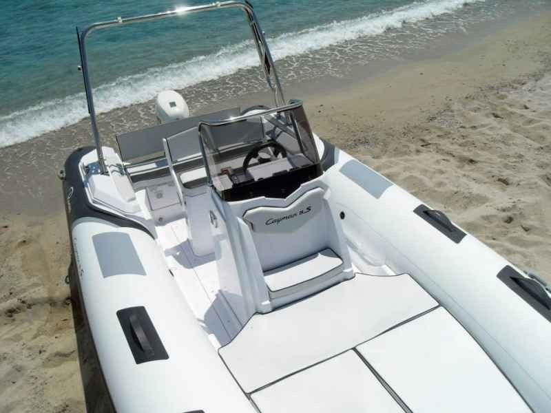 Inflatable boat on a sandy beach beside turquoise water