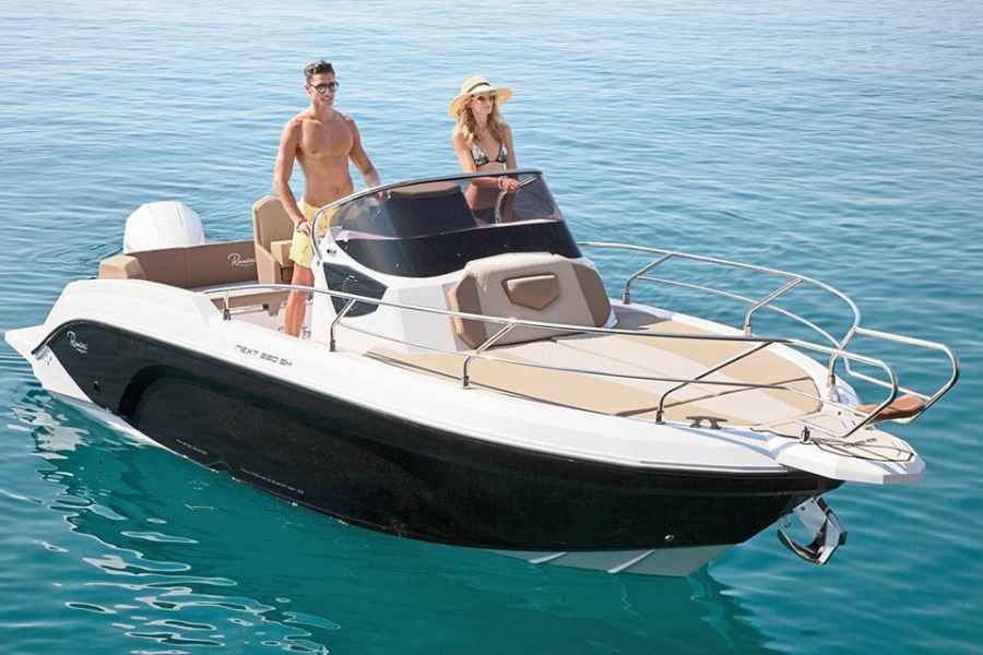 Two people on a small white-and-black motorboat sailing on clear blue water