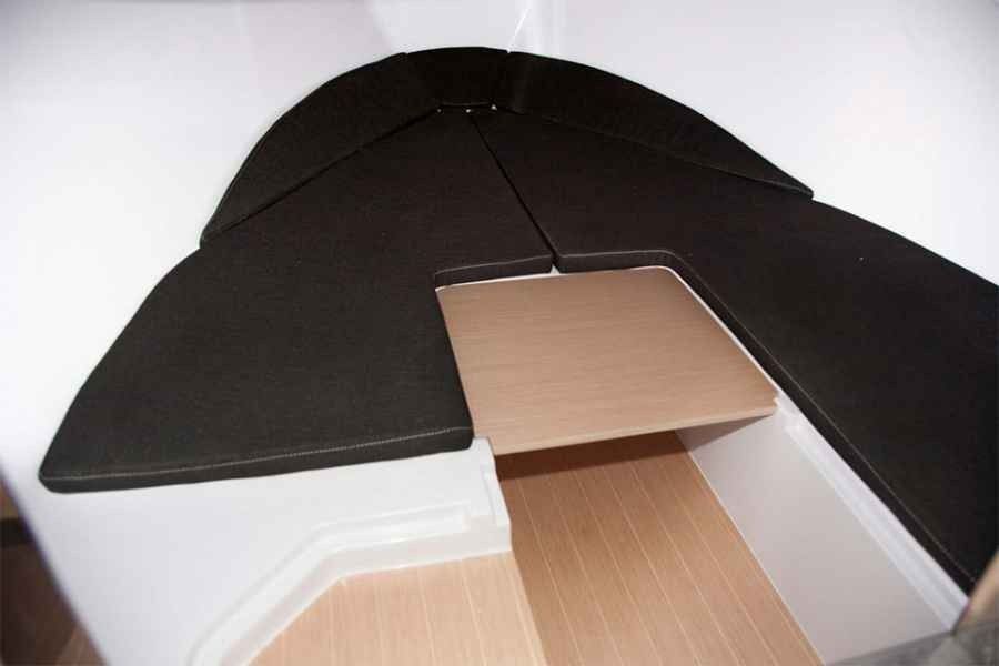 Black umbrella-like canopy over a cardboard opening in a white interior space