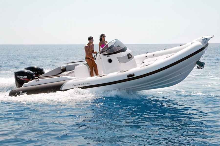 Two people riding a white motorboat on choppy blue water