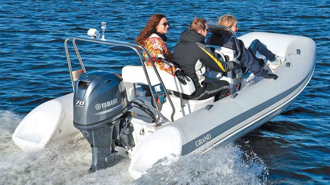 Grand Silver Line 470 Inflatable motorboat speeding on blue water with several passengers aboard