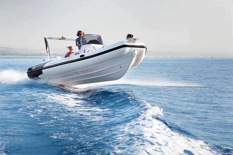 Ranieri Cayman 23 Sport Touring Rib Speedboat skimming across blue water, leaving a white wake under a clear sky.