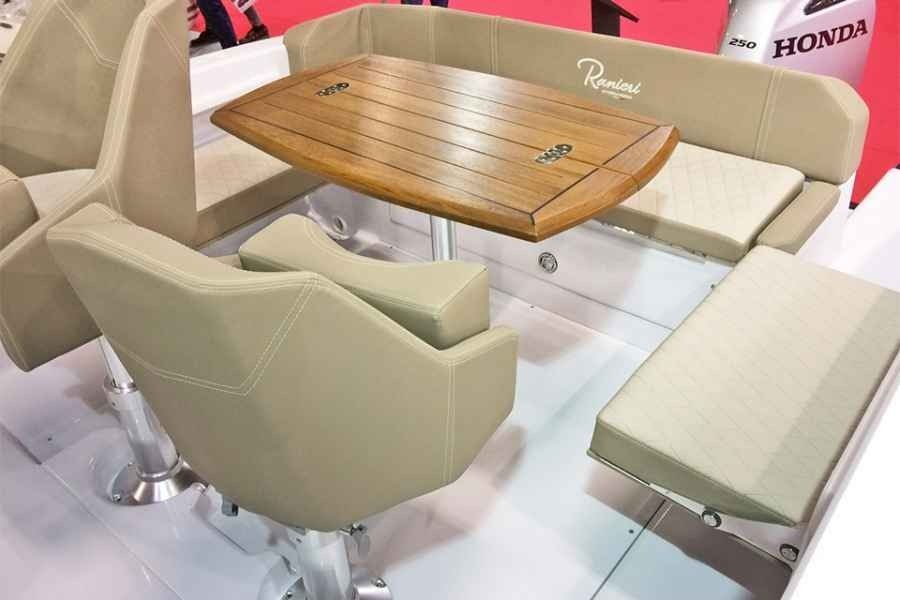 Beige upholstered boat seating around a wooden table in a showroom display
