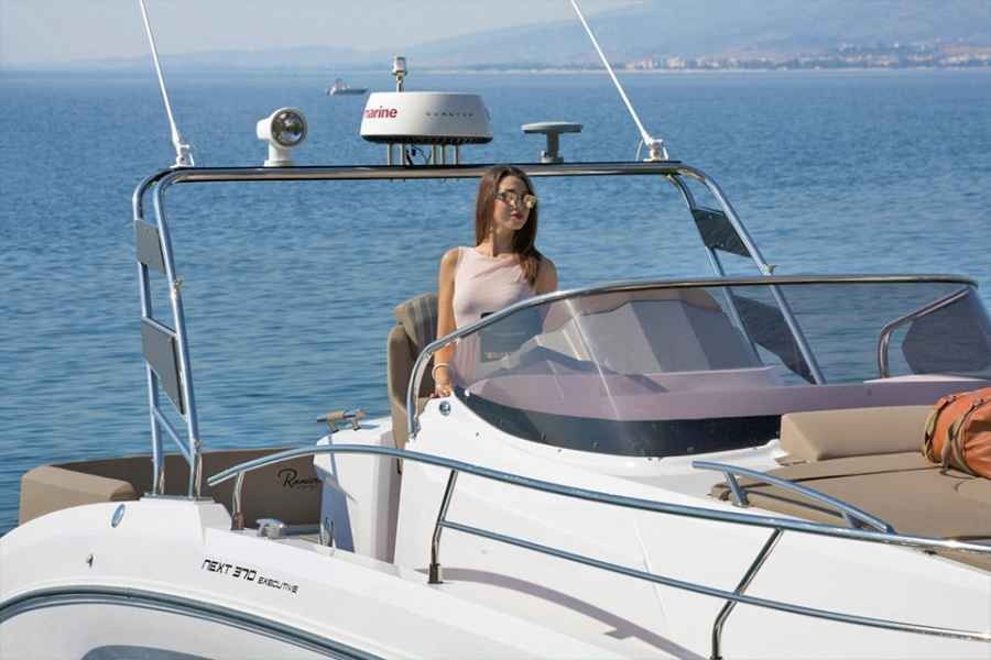 Woman standing on a white ranieri 370 executive boat on calm blue water near the coast