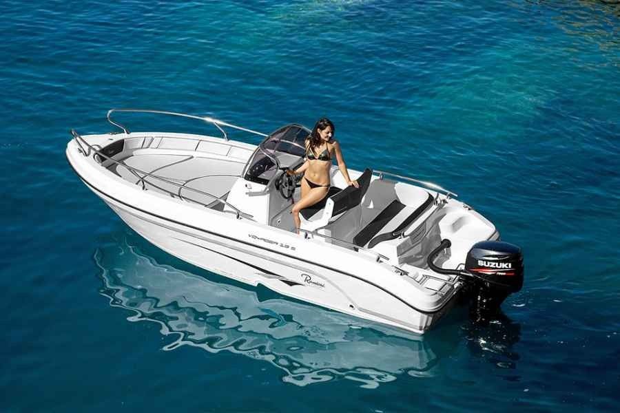 Woman sitting on a white speedboat on clear blue water