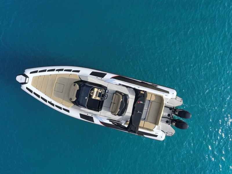 Aerial view of a white luxury Ranieri Cayman 35 Executive on turquoise water with a tan deck and black accents