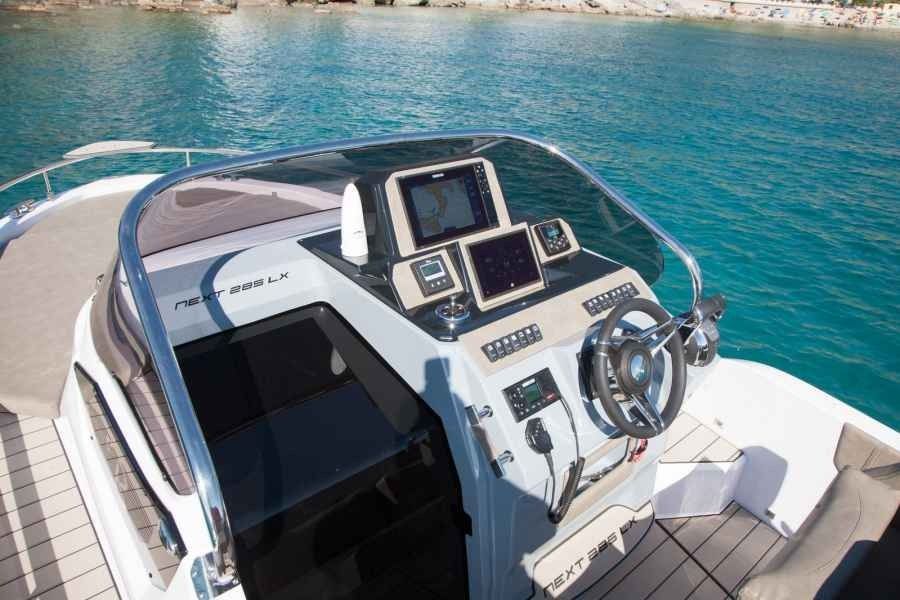 Boat helm and dashboard on a yacht with turquoise water in the background