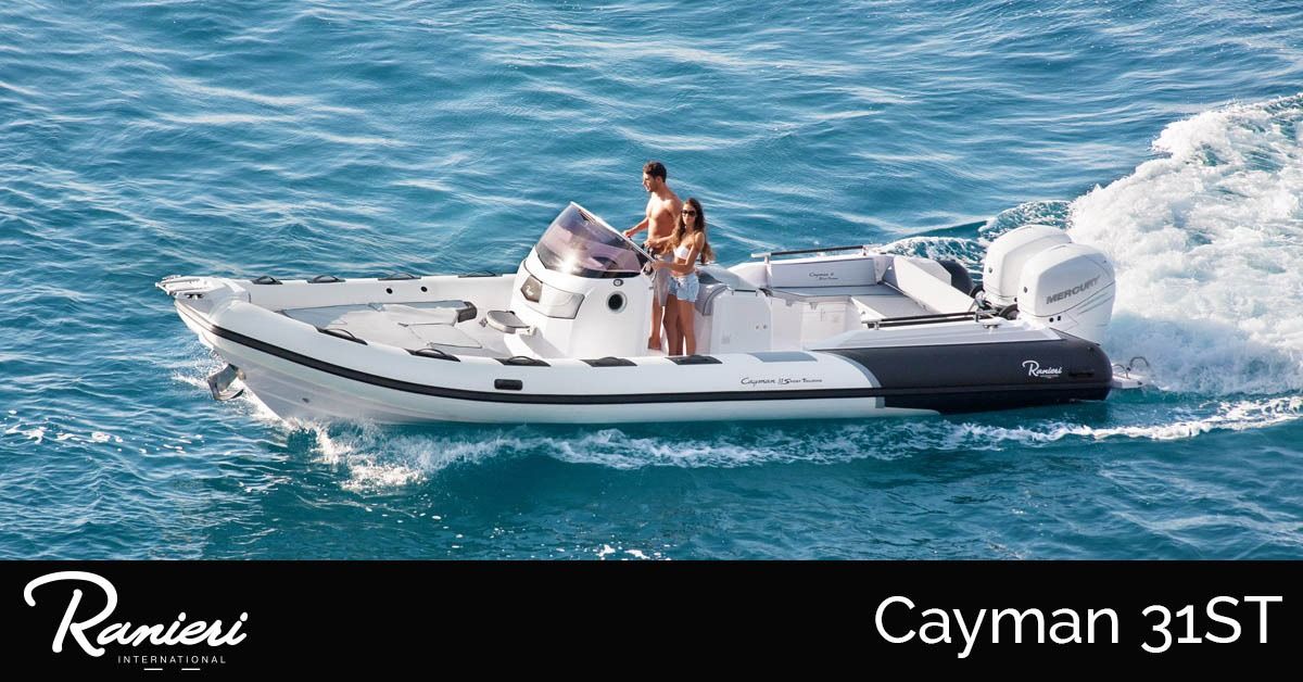 White ranieri Cayman 31ST boat speeding across blue water with two people aboard