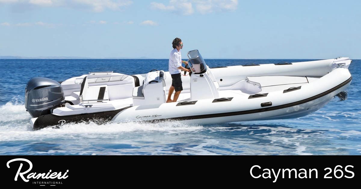 White RIB speedboat on blue water with a person standing near the helm; ranieri Cayman 26S