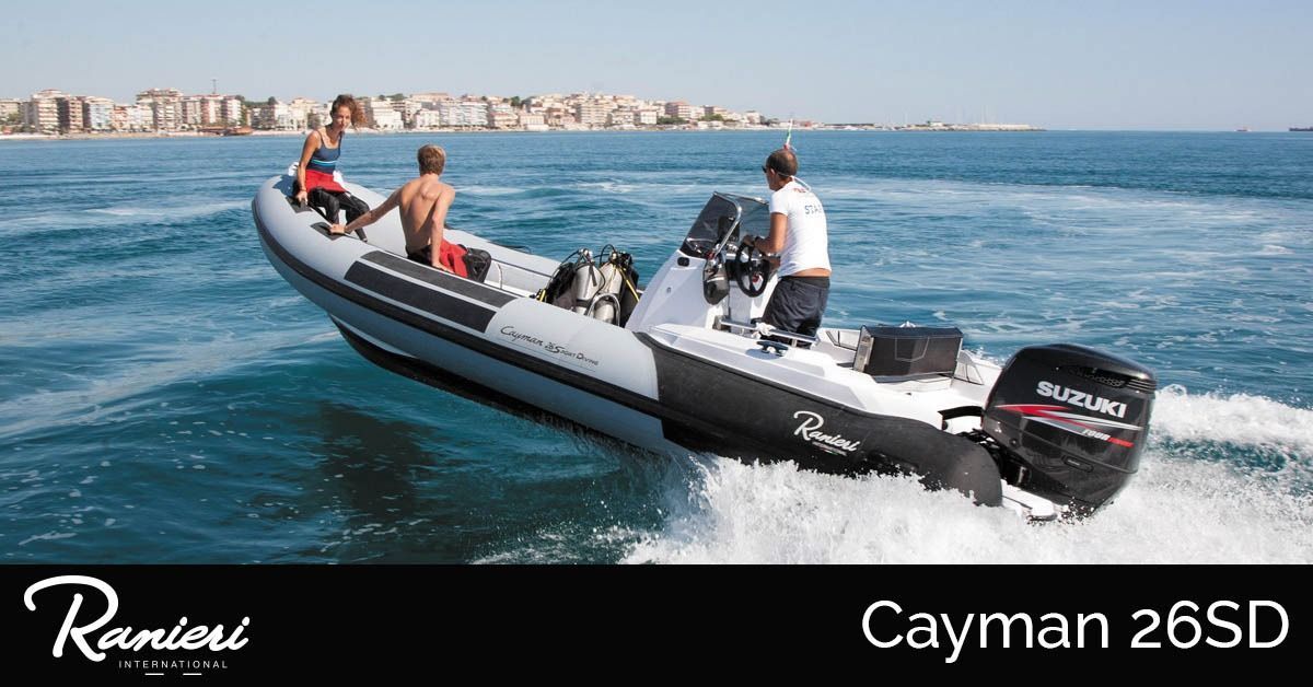 Black-and-white speedboat with people riding on blue water, labeled Cayman 26SD