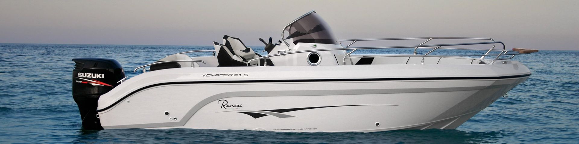 White speedboat cruising on calm water with a small outboard motor and a person at the helm