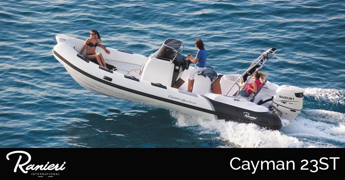 Four people riding in a white RIB speedboat on blue water, labeled Cayman 23ST.