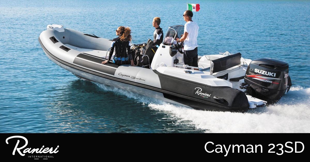 Rib boat on blue water with passengers, showing Cayman 23SD branding and twin outboard motors