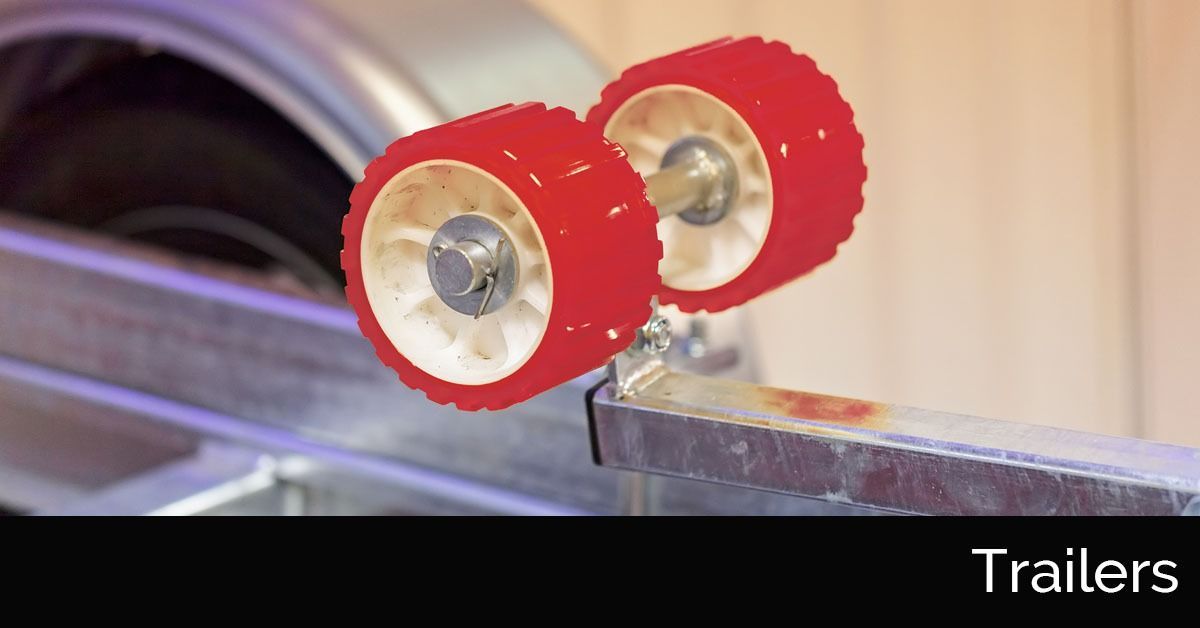 Red rollers mounted on a metal arm beside a machine, labeled “Trailers”