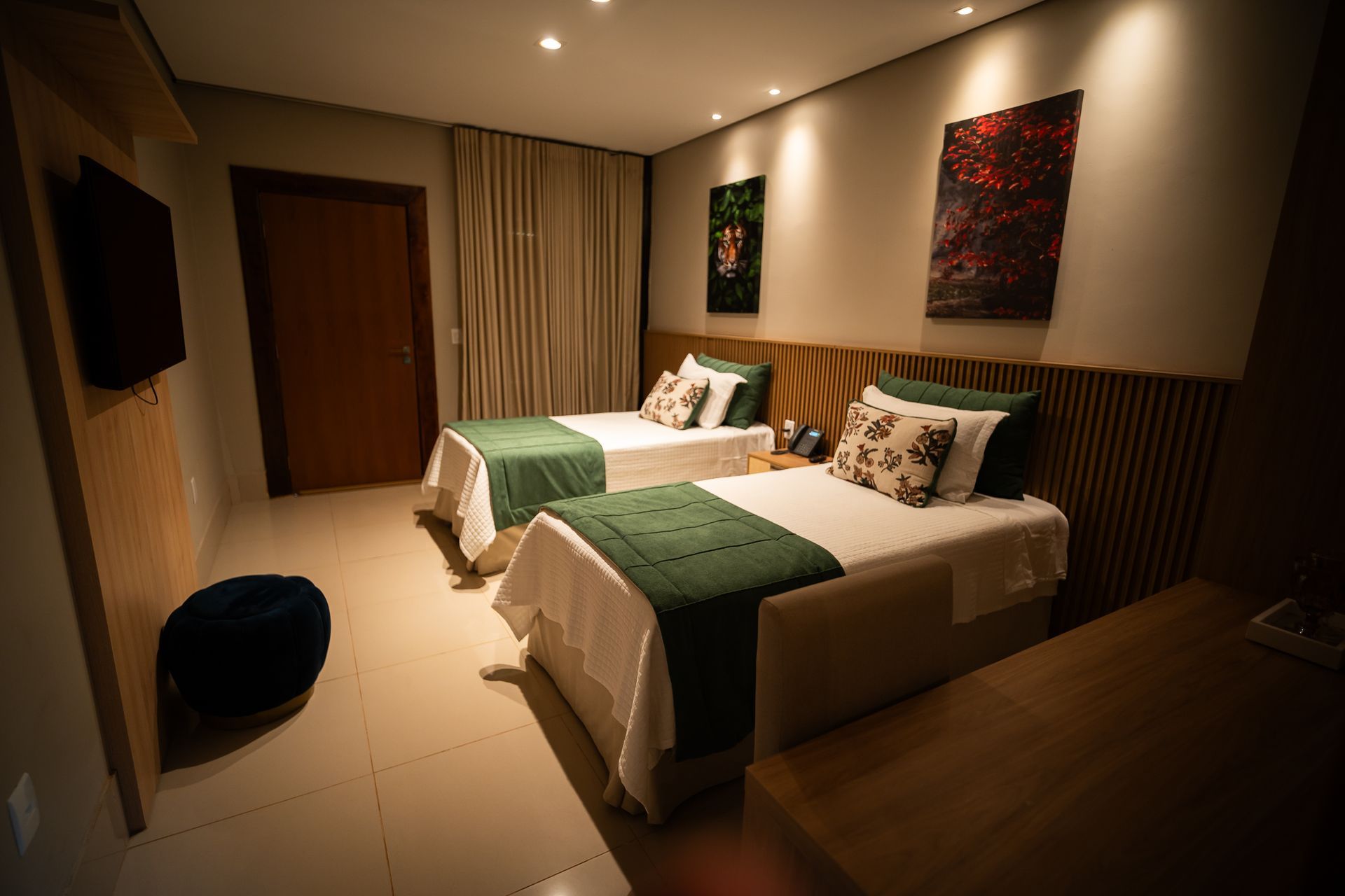 Um quarto de hotel com duas camas e uma televisão.