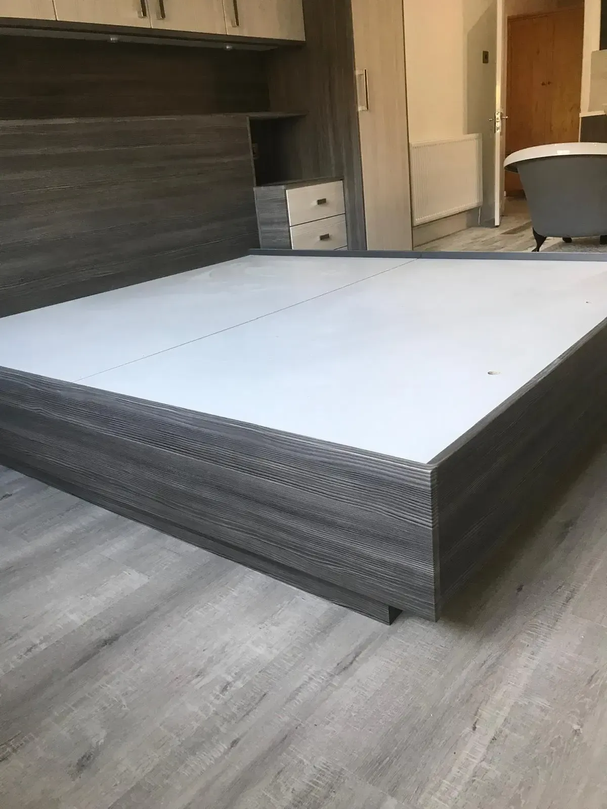 Stack of white-and-black foam boards on a floor in a room with a fireplace.