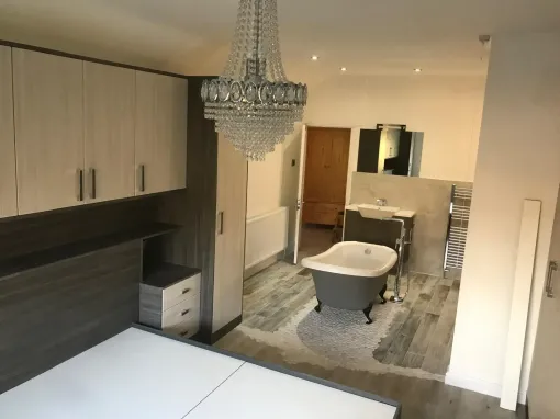 Bedroom with chandelier, wardrobe, and a bed in a modern furnished room