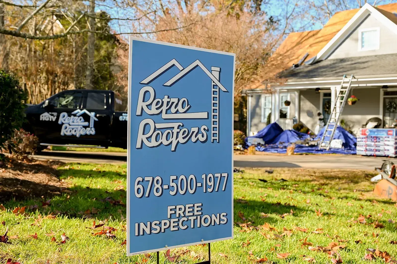 Sign for Retro Roofers, phone number, in front of a house, and a truck.