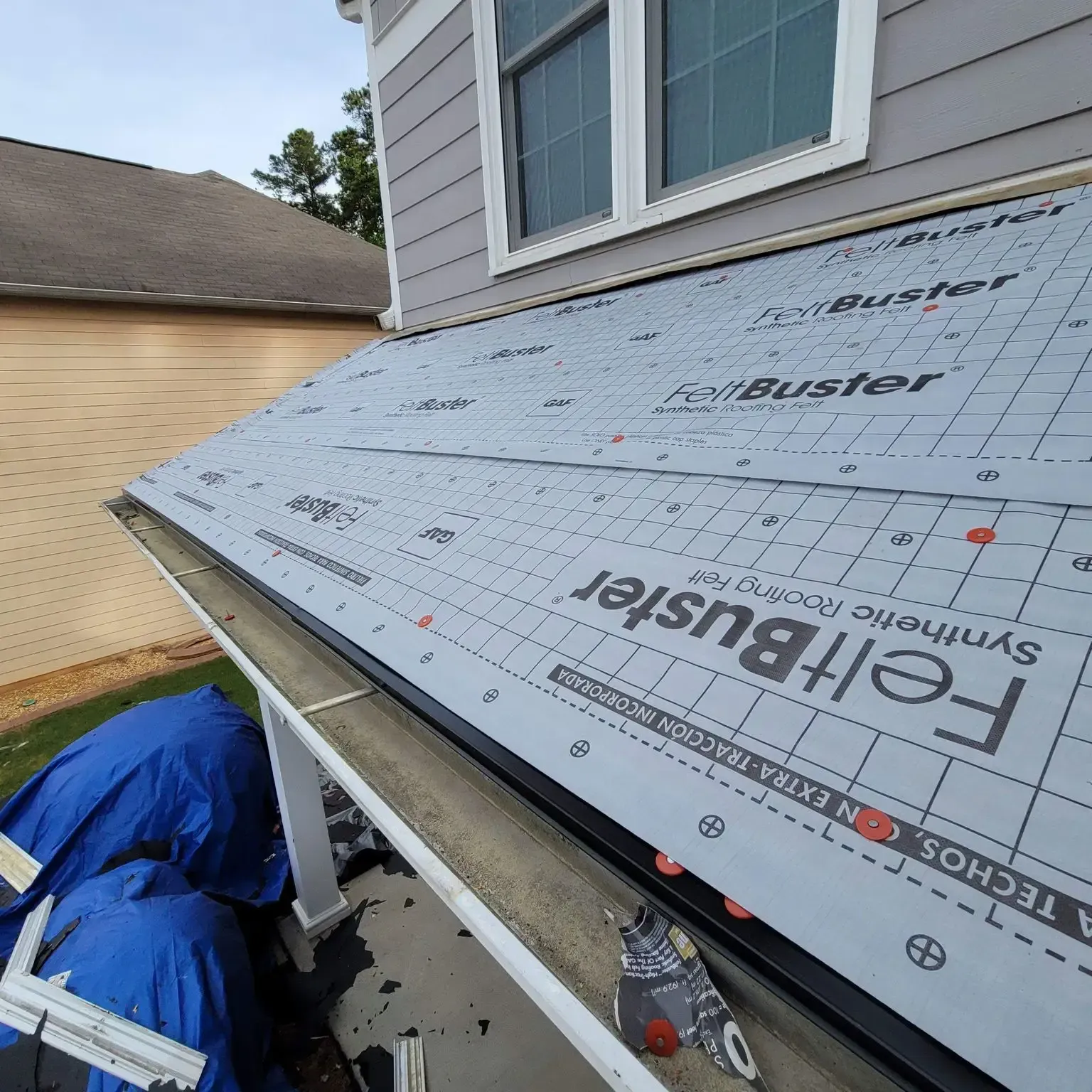 Roof underlayment being installed on a house, a roll of